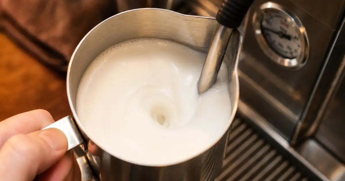 Steaming milk for a latte — stretching milk with a steam wand to silky microfoam